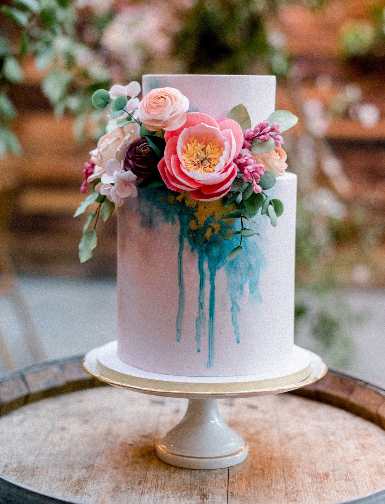 The wedding cake combined pink and teal and lush fresh blooms