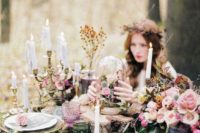 10 a romantic enchanted forest wedding table with moss, foliage, pink blooms, dried herbs and lots of candles