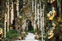 13 a unique pathway to the ceremony or reception space with arches with vines and floral garlands hanging down