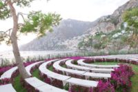 15 a modern and super bold wedding aisle with white semi circle benches and bright purple blooms lining them