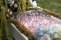 16 an enchanted forest wedding drink station with a cart decorated with moss, pastel blooms and greenery