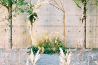17 a modern meets boho wedding aisle with ghost chairs, pampas grass arrangements and a matching arch with pampas grass