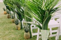 19 a modern tropical wedding aisle with pineapples and lush palm leaves that line it up and make the aisle look tropical