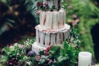 21 a buttercream wedding cake with fresh greenery and dark blooms, one a tree stump with ferns, blooms and candles
