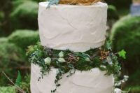22 a buttercream wedding cake with greenery and moss with a fake nest with blooms on top is a cool wedding idea