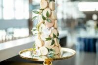 a blush macaron tower with greenery is a cool and pretty idea for a spring or summer wedding, it looks chic and elegant