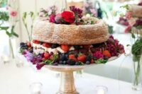 a bundt wedding cake filled with whipped cream, with bold blooms and fresh berries is a fab idea for a summer wedding and can be used for a fall one, too
