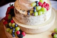 a cheese wheel tower topped with berries and fruit is a lovely idea for a vineyard wedding, it’s an alternative to a traditional sweet wedding cake