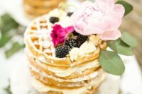a delicious waffle wedding cake with blackberries, cream and a large pink peony on top for a summer wedding