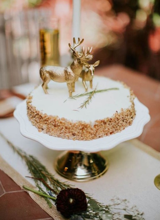 a krispie rice weddig cake with a creamy top, herbs and chic gold deer toppers for a woodland wedding