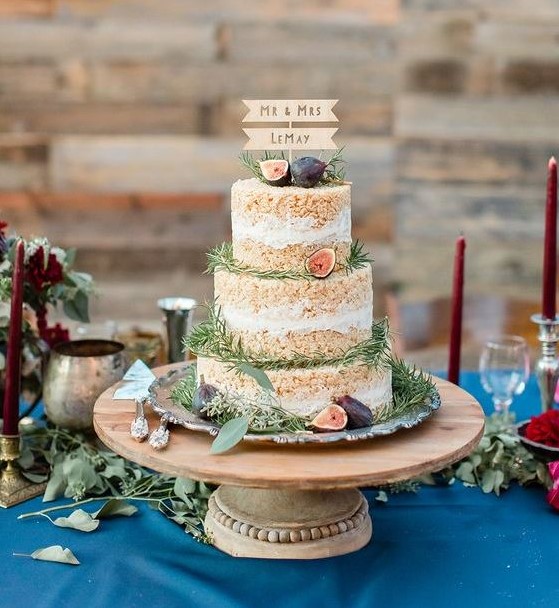 a krispie rice wedding cake with fresh figs and greenery plus a cute wooden topper is a chic rustic piece