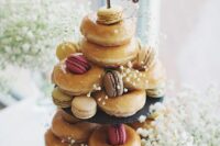 a lovely stand with glazed donuts and macarons, with baby’s breath and a calligraphy topper is a cool alternative to a wedding cake
