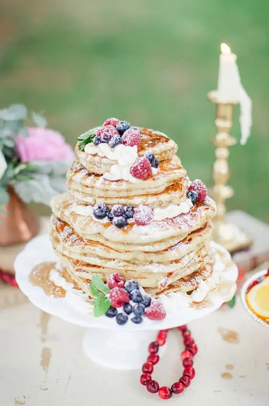 a pancake wedding cake with fresh flowers and fruits and sugar powder is a lovely idea for a brunch wedding