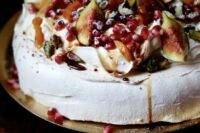 a pavlova wedding cake topped with fresh figs, berries and pomegranate, with berry drip is a delicious idea for a fall wedding