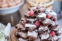 a small and tasty-looking brownie stack with fresh berries is a simple and lovely alternative to a usual wedding cake