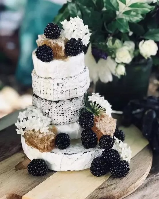 a small cheese wheel wedding cake topped with blackberries, white blooms and honey combs is a lovely idea for a summer or fall wedding