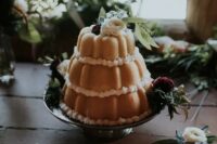 a three-tier bundt wedding cake with white and deep purple blooms and greenery is a beautiful idea for a relaxed wedding