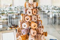 a tower with holders and delicious glazed donuts plus a heart topper is a cool idea for a wedding