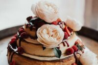 a two-stacked cheesecake topped with flowers and berries looks cute and absolutely delicious and adorable