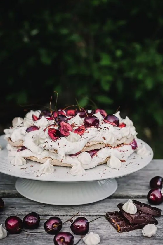 a vegan black forest pavlova meringue cake is a beautifully crispy, fluffy and sweet cake for summer filled with cream, chocolate and cherries