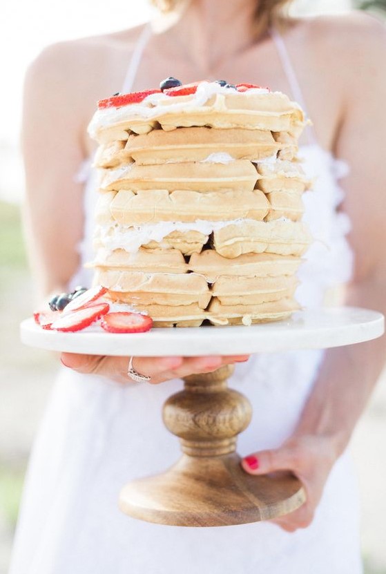 a waffle wedding cake topped with strawberries and blueberries is a cute and delicious idea