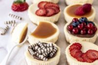 an assortment of mini cheesecakes with fresh berries and berry slices, salted caramel and mini chocolate bites