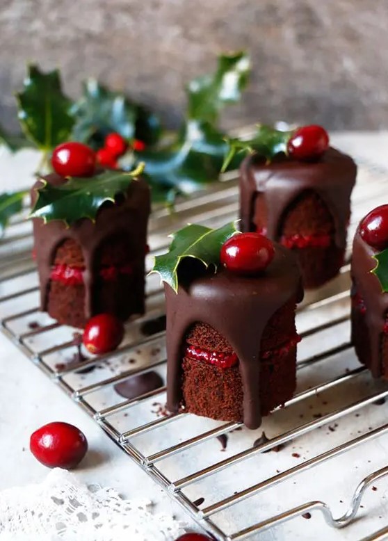 individual naked wedding cakes with cranberry jam, chocolate dripping, cranberries and holly leaves on top