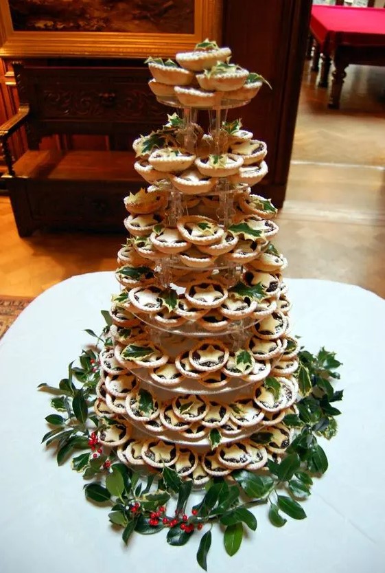make a tower of traditional for Christmas mince pies with cookie leaves and adorn the tower with real foliage