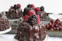 mini chocolate bundt cakes with chocolate drip and fresh berries on top are adorable for a wedding, they look and taste delicious