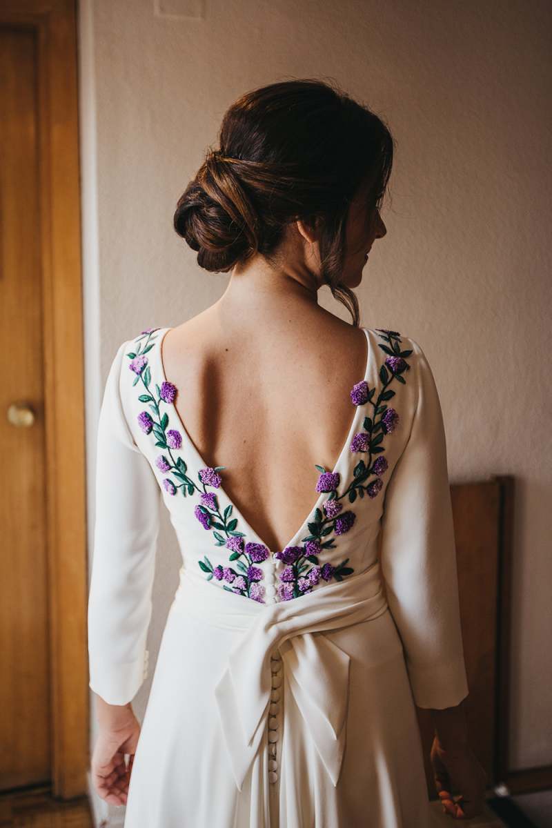 Her dress was featuring purple and lilac embroidered flowers and leaves, a cutout back on buttons and a long train