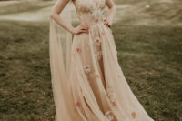 03 The bride was wearing a beautiful nude wedding dress with floral appliques, a gauzy skirt, an open back and a capelet