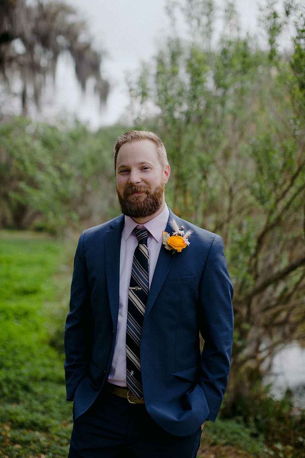 The groom was wearing a navy suit, a blush shirt and a striped tie plus a bright boutonniere