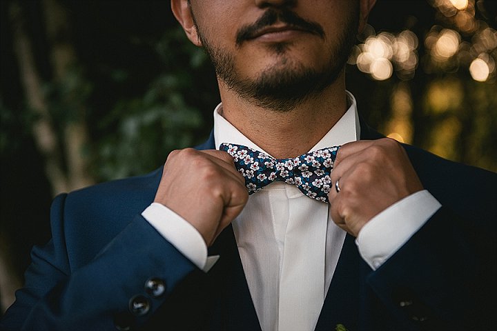 The groom was wearing a navy suit, a white shirt and a floral bow tie