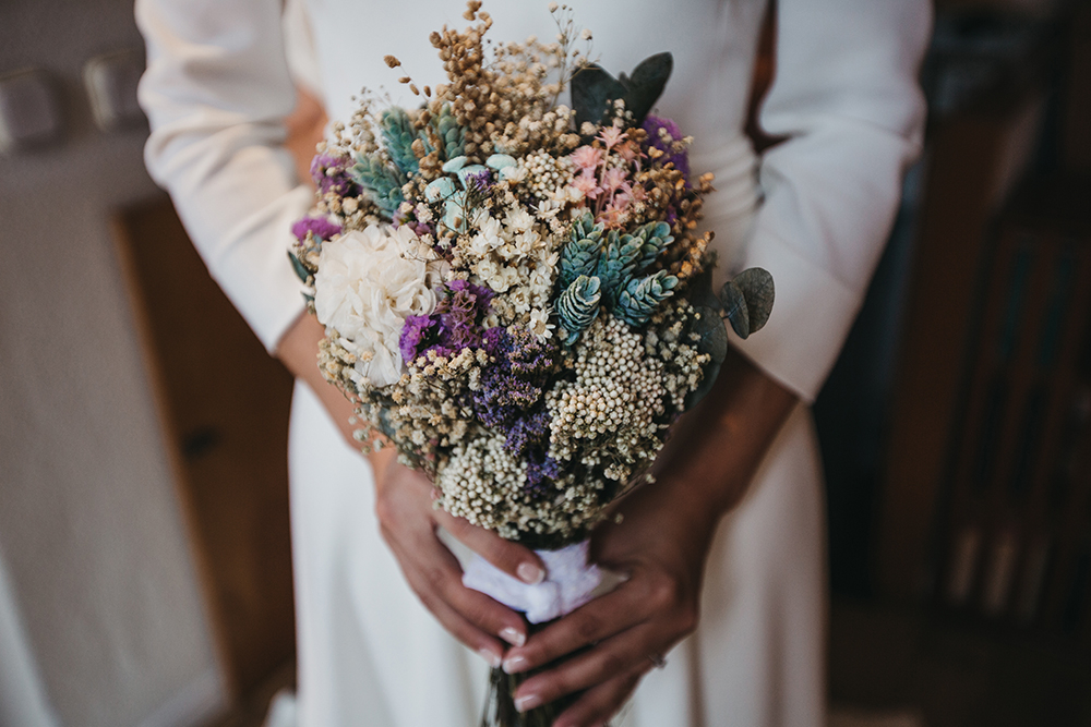 The wedding bouquet consisted of dried blooms and greenery, herbs and foliage and a right amount of purple and lilac