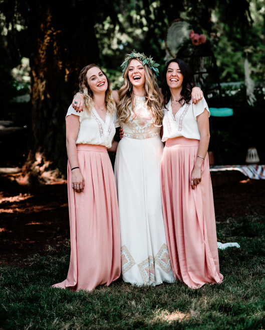 The bridesmaids were wearing pink pleated maxi skirts, white tops with embroidery and loose waves