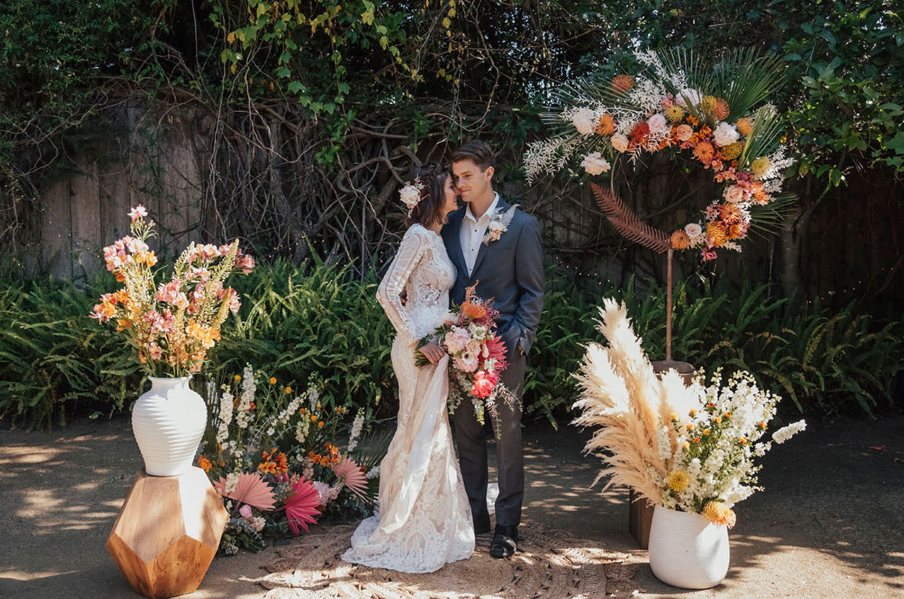 The wedding ceremony space was done with pampas grass, dried and colorful blooms, geometric touches and fronds