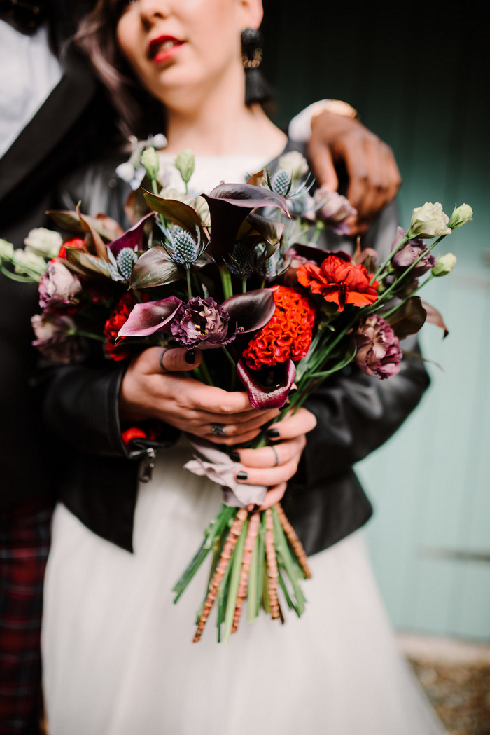 The wedding bouquet was done in moody shades, deep purple, orange, dusty pink and moody foliage