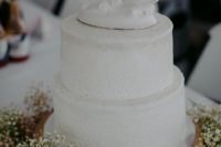 09 The wedding cake was a white textural one, served with baby’s breath and topped with swans