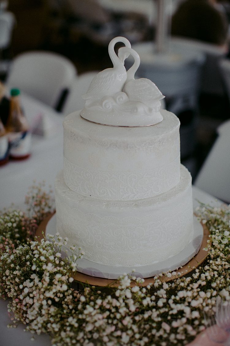 The wedding cake was a white textural one, served with baby's breath and topped with swans