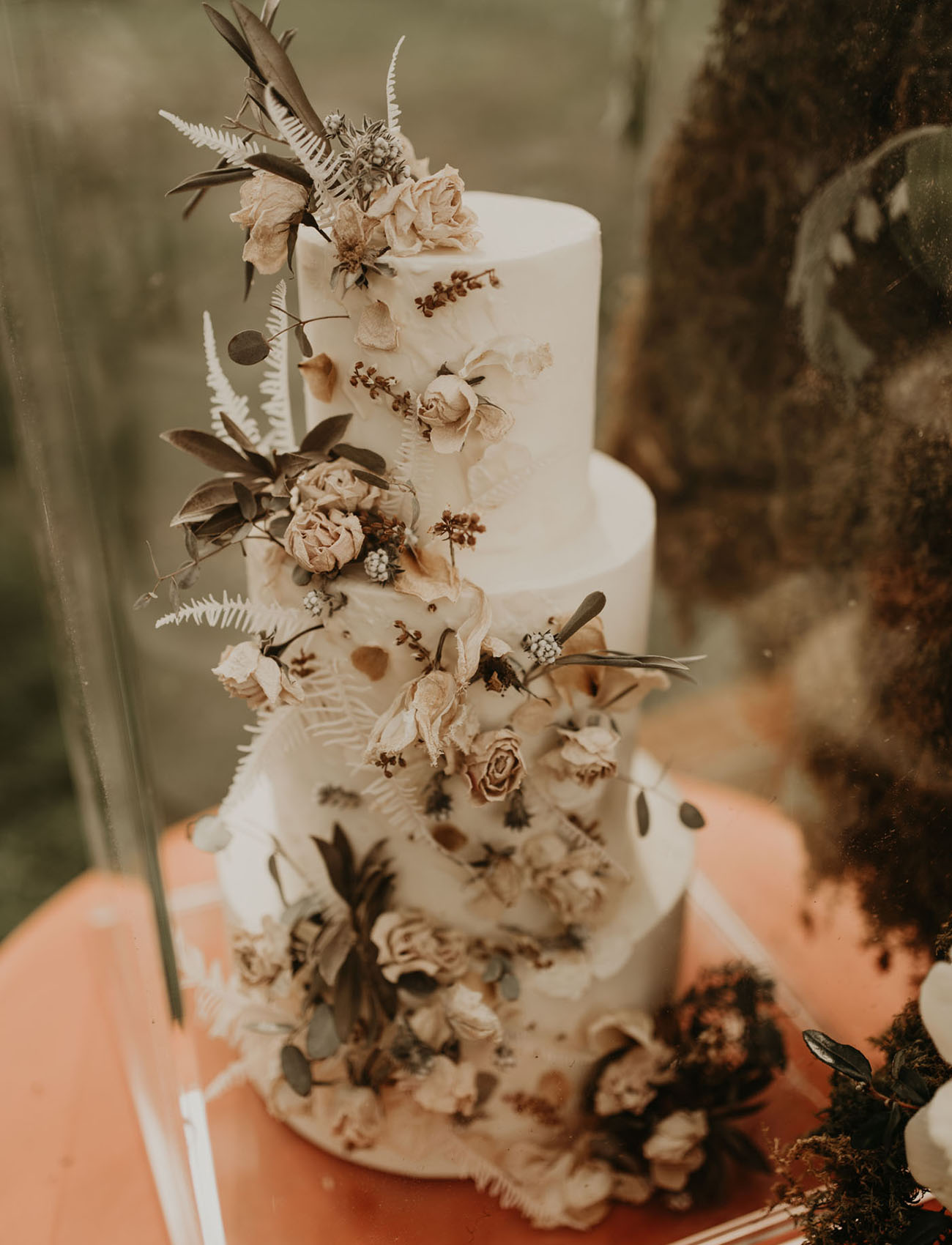 The wedding cake was a white one with dried blooms and herbs and leaves for a decadent feel