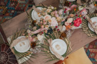 10 The wedding tablescape was done with wicker chargers, palm fronds, lush pink and blush blooms and pampas grass