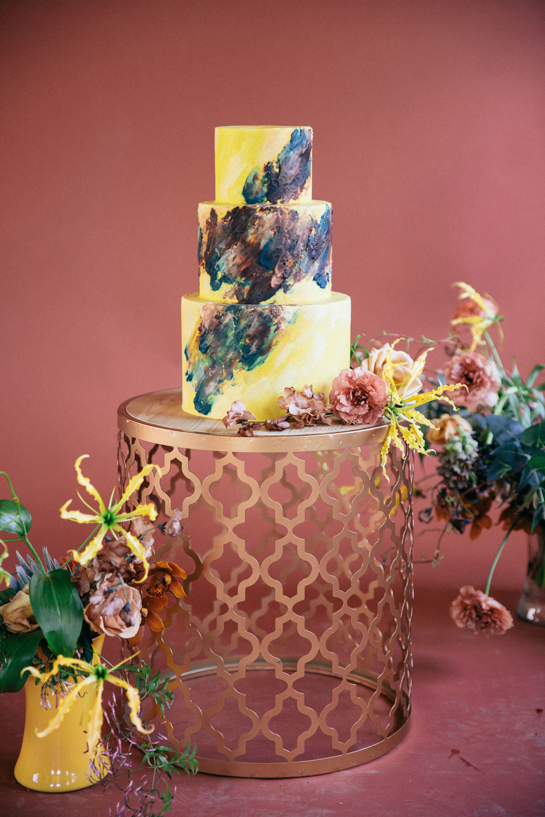 The wedding cake was done in bright yellow and decorated with dark and pastel brushstrokes