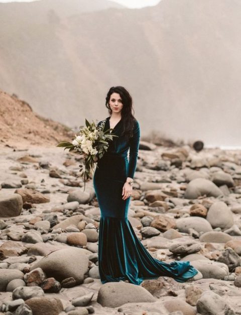 a teal velvet mermaid dress with long sleeves, a V-neckline and a train is a statement idea for a fall or moody bride