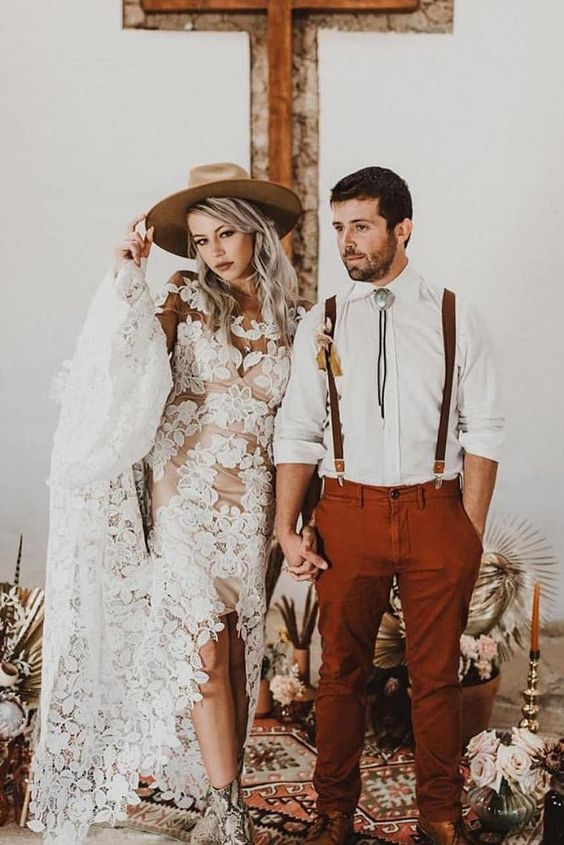 a boho groom's look with a white shirt, rust pants, brown suspenders and a bolo tie is easy to repeat and looks cool
