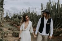 a boho groom’s outfit with a white shirt, grey pants, brown shoes, a black waistcoat and a grey hat is a cool and pretty idea