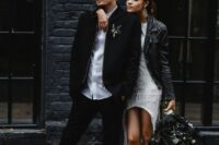 a casual groom’s outfit with a white shirt, black pants, a black jacket and white sneakers plus a cap on top