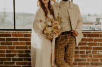 a creamy turtleneck, a creamy jacket, rust-colored windowpane pants, tan Chelsea boots are a great look for a boho wedding