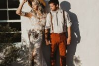a relaxed boho groom’s look with a white shirt, rust pants and matching suspenders, a bolo tie and brown shoes