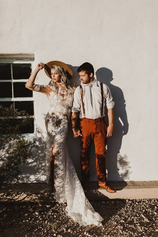 a relaxed boho groom's look with a white shirt, rust pants and matching suspenders, a bolo tie and brown shoes
