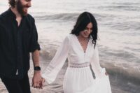 a relaxed total black groom’s look with a shirt and cuffed pants is a cool idea for a boho beach wedding or a coastal one